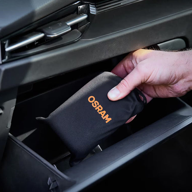 Hånd placerer Osram TYREinflate 1600 i opbevaringspose i bilens handskerum