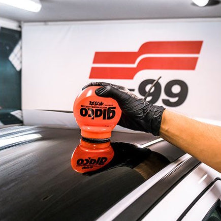 Hand met Glaco Roll-on Max ruitcoating op autoruit voor ultra hydrofobe werking