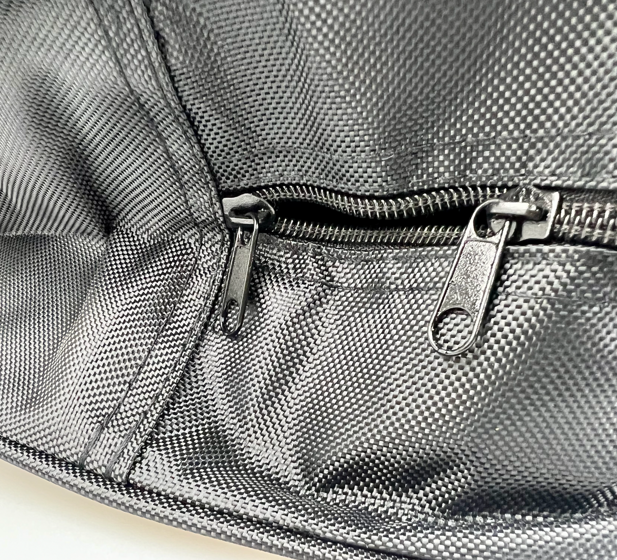 Details van een zwarte opbergtas voor laadkabel met ritssluiting