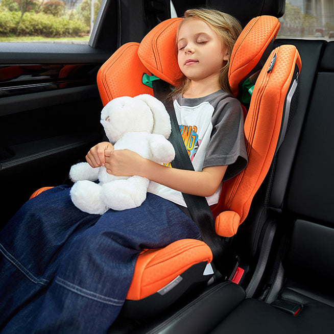 Barn sover i Recaro Axion 1 autostol i bilen med bamse i armene, orange model