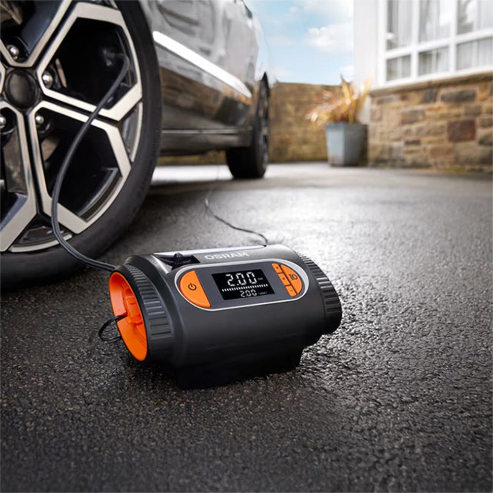 Osram TYREinflate 2120 kompressor på indkørsel forbundet til bil i baggrunden