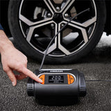 Person trykker på knap på Osram TYREinflate 2120 kompressor foran bildæk