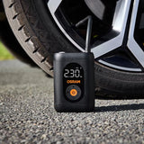 Osram TYREinflate 1600 står på grus foran bildæk, display viser 230 kPa