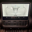 Touchscreen in Tesla Model 3/Y, die een ventilatiecover toont gemonteerd op de middenconsole van de auto.