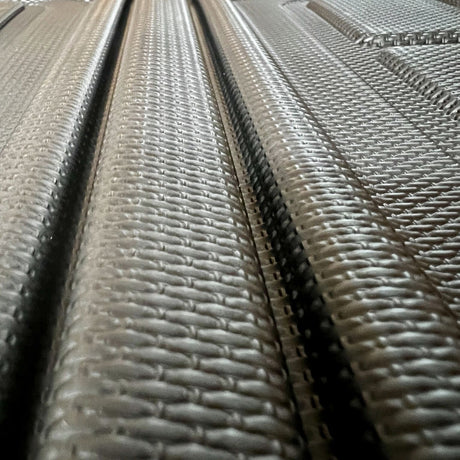 Close-up van een zwarte kofferbakmat met een gestructureerd antislippatroon