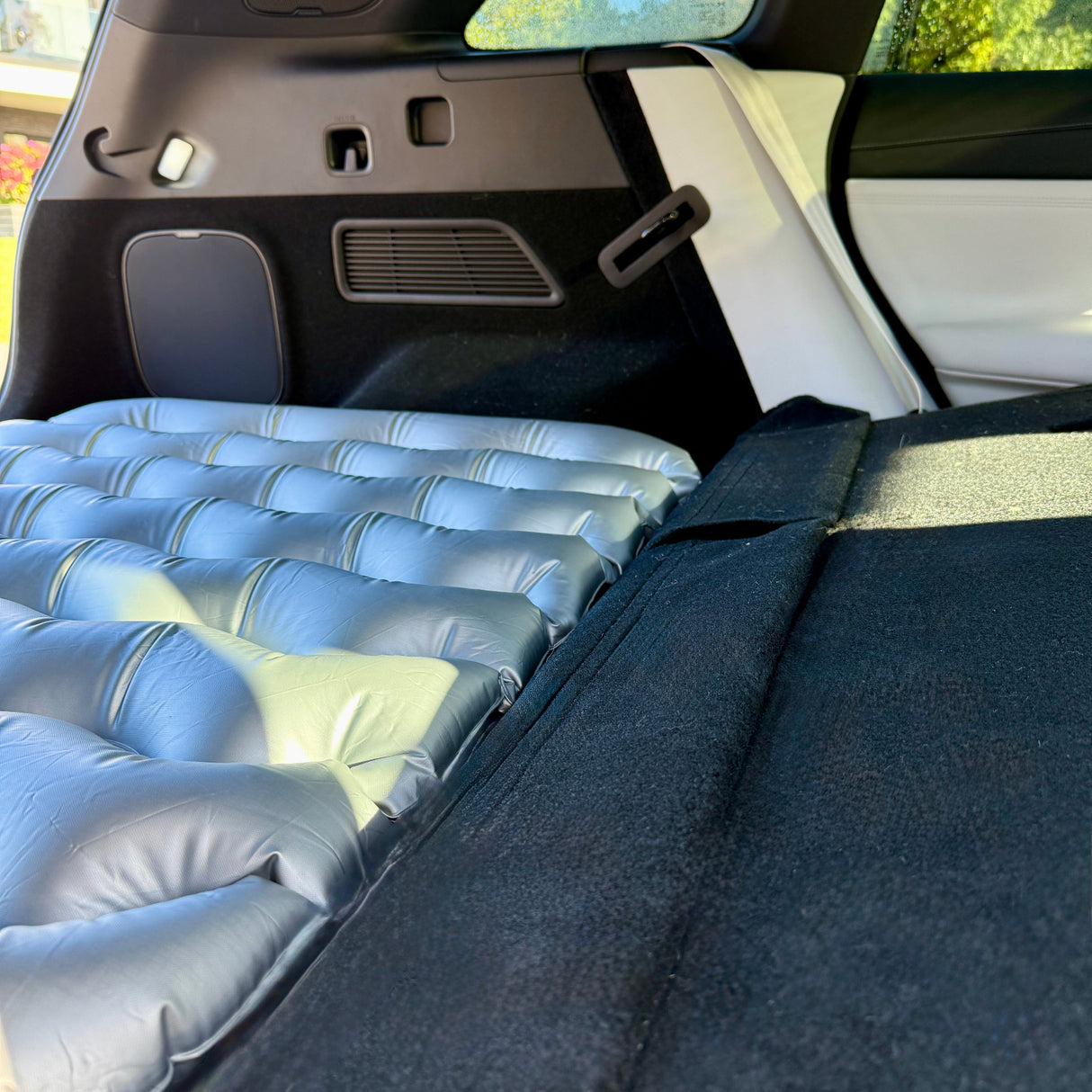 Afbeelding van een luchtmatrassteun in de auto, die extra ruimte in de kofferbak biedt.