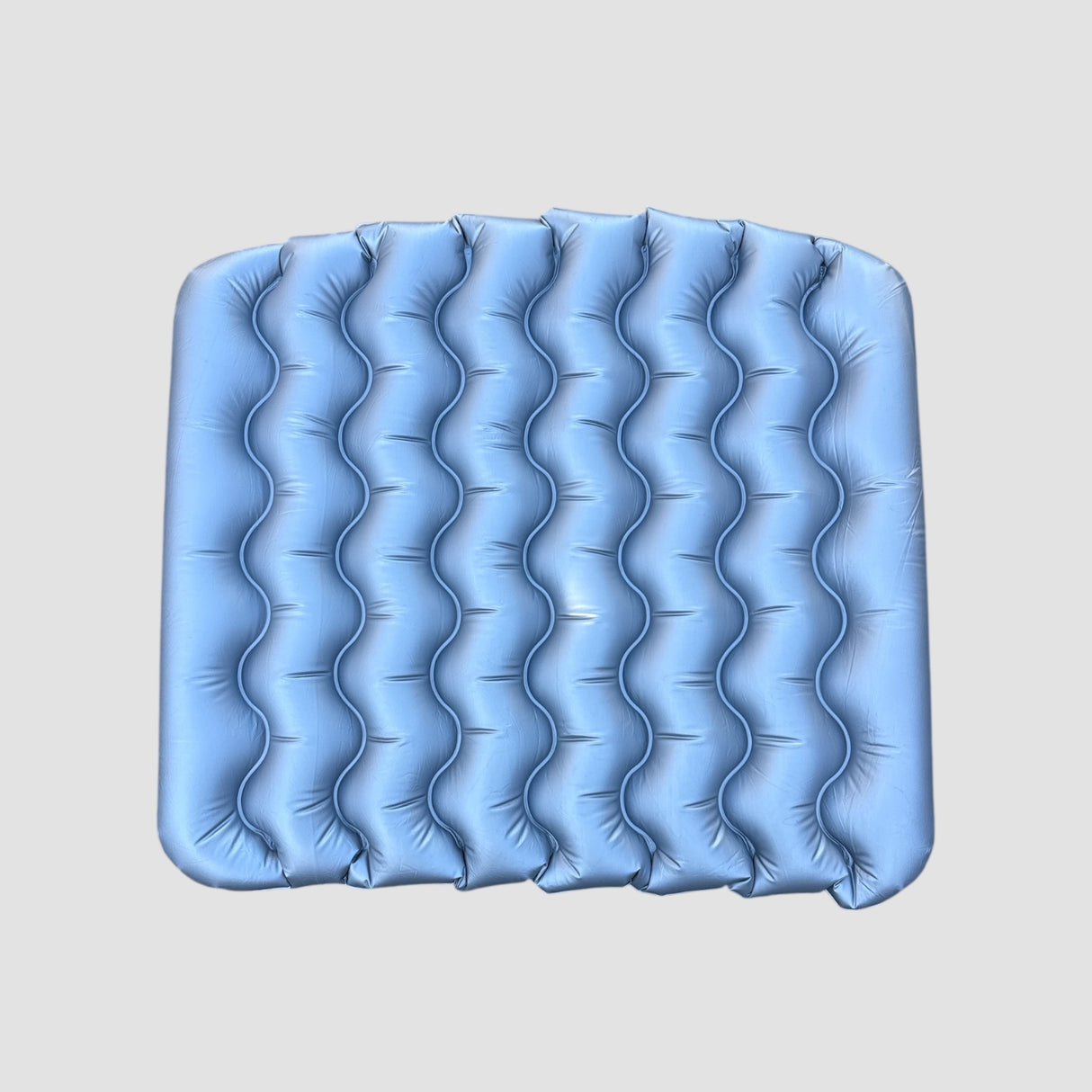 Blauw ondersteunend matras met golvend oppervlak voor gebruik in de kofferbak van de auto.