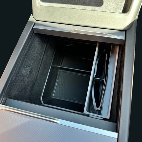 Zonnebrillenhouder geïnstalleerd in de middenconsole van een Tesla met een zonnebril geplaatst in de houder.