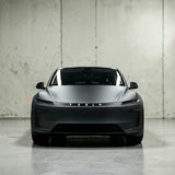 Tesla Model Y 2025 Juniper set forfra i mat grå, viser TESLA logo på lystribe